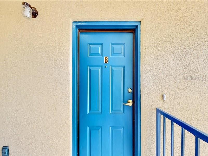 A bright blue door labeled with the letter B is set in a beige wall — 206 MAJORS LANE UNIT B, KISSIMMEE, FL