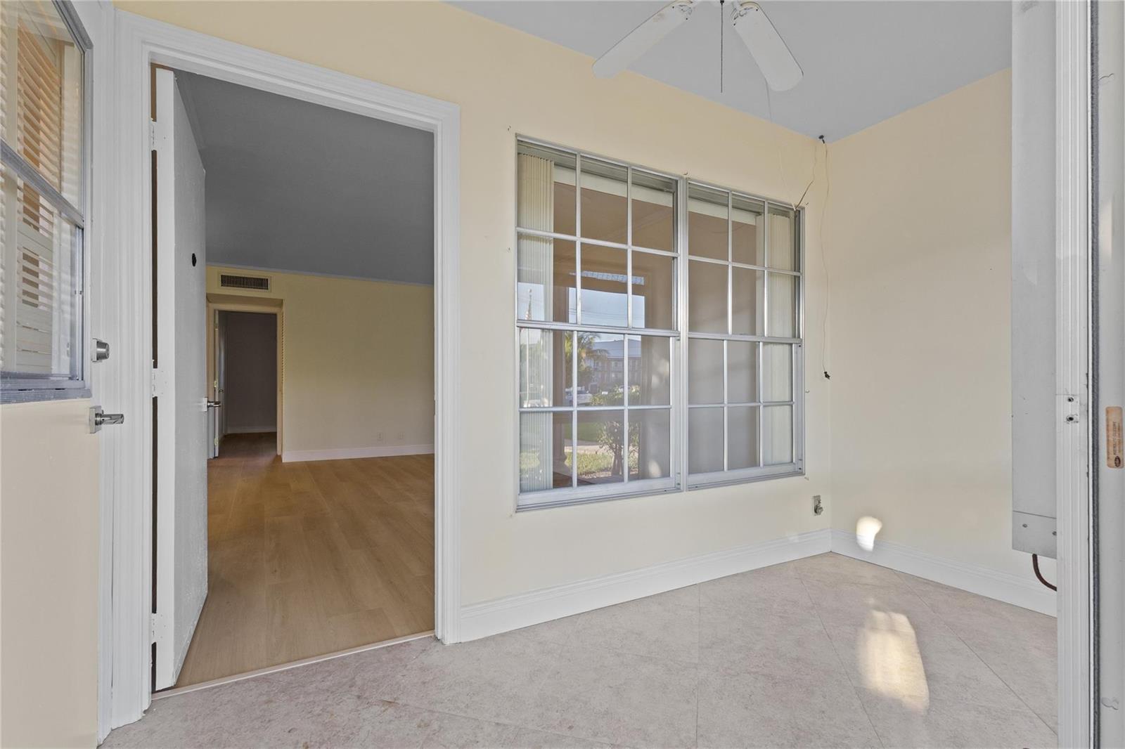 A sunroom with tile flooring, a ceiling fan, and a doorway leading into a living area — 1965 SE 5th Court # 104, Pompano Beach FL 33060, POMPANO BEACH, FL
