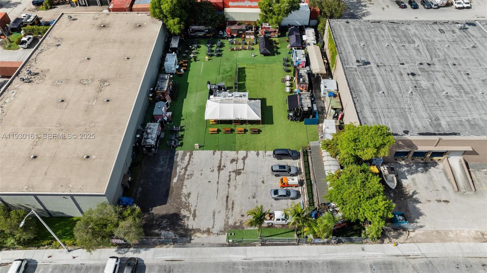 An aerial view shows an outdoor food truck park with a central tent and parking — 7070 NW 84th Ave, Medley FL 33166, MEDLEY, FL