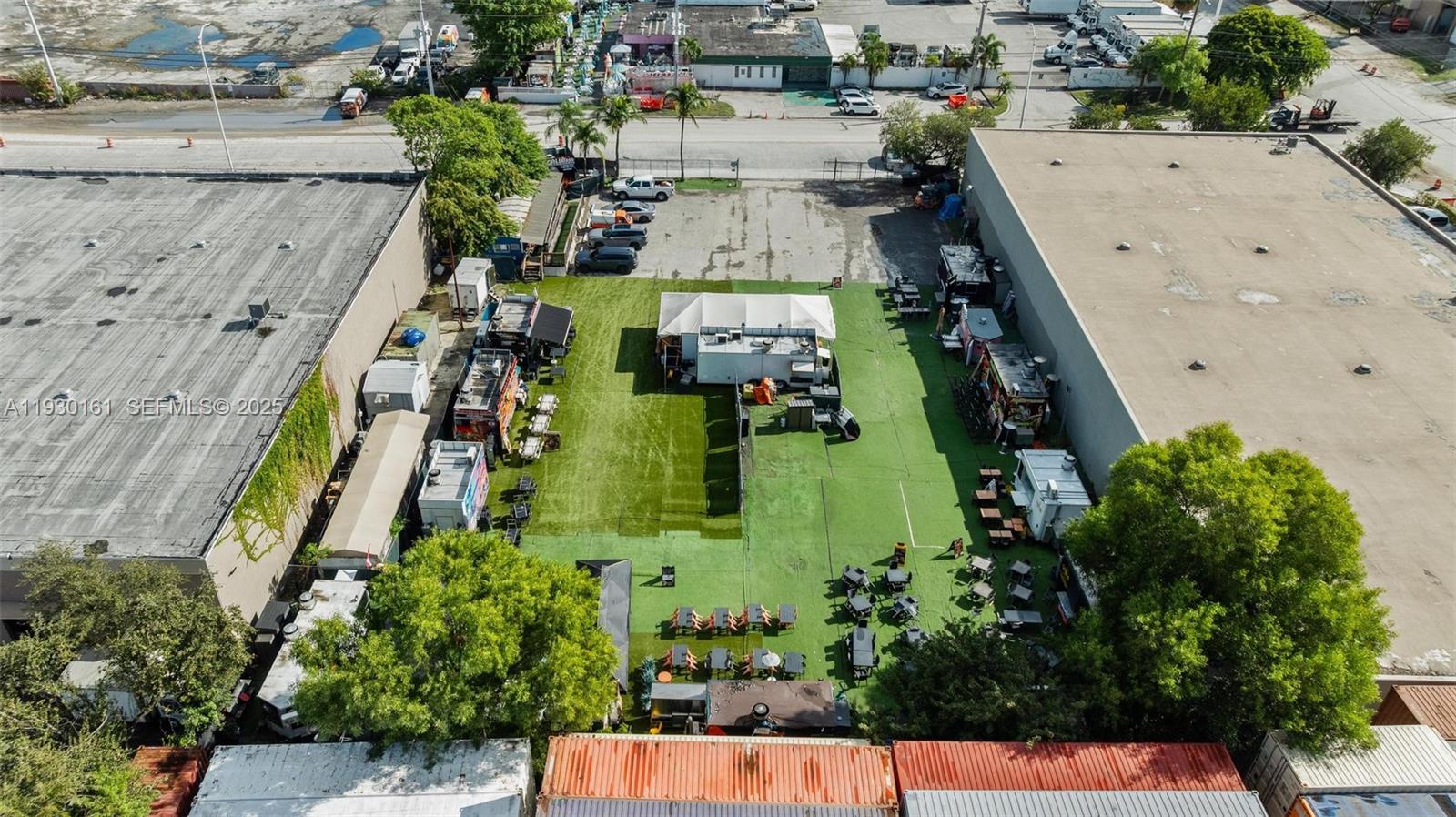 An aerial view shows an outdoor food truck park with seating areas and a tent — 7070 NW 84th Ave, Medley FL 33166, MEDLEY, FL