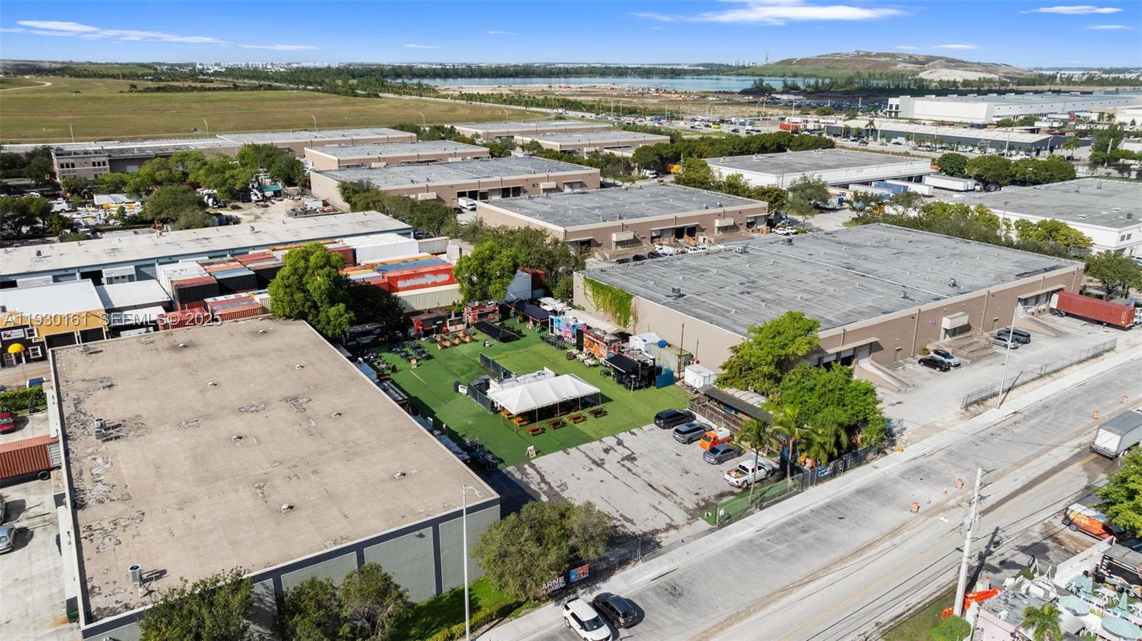 An aerial view shows a commercial property with a central outdoor event space and parking — 7070 NW 84th Ave, Medley FL 33166, MEDLEY, FL