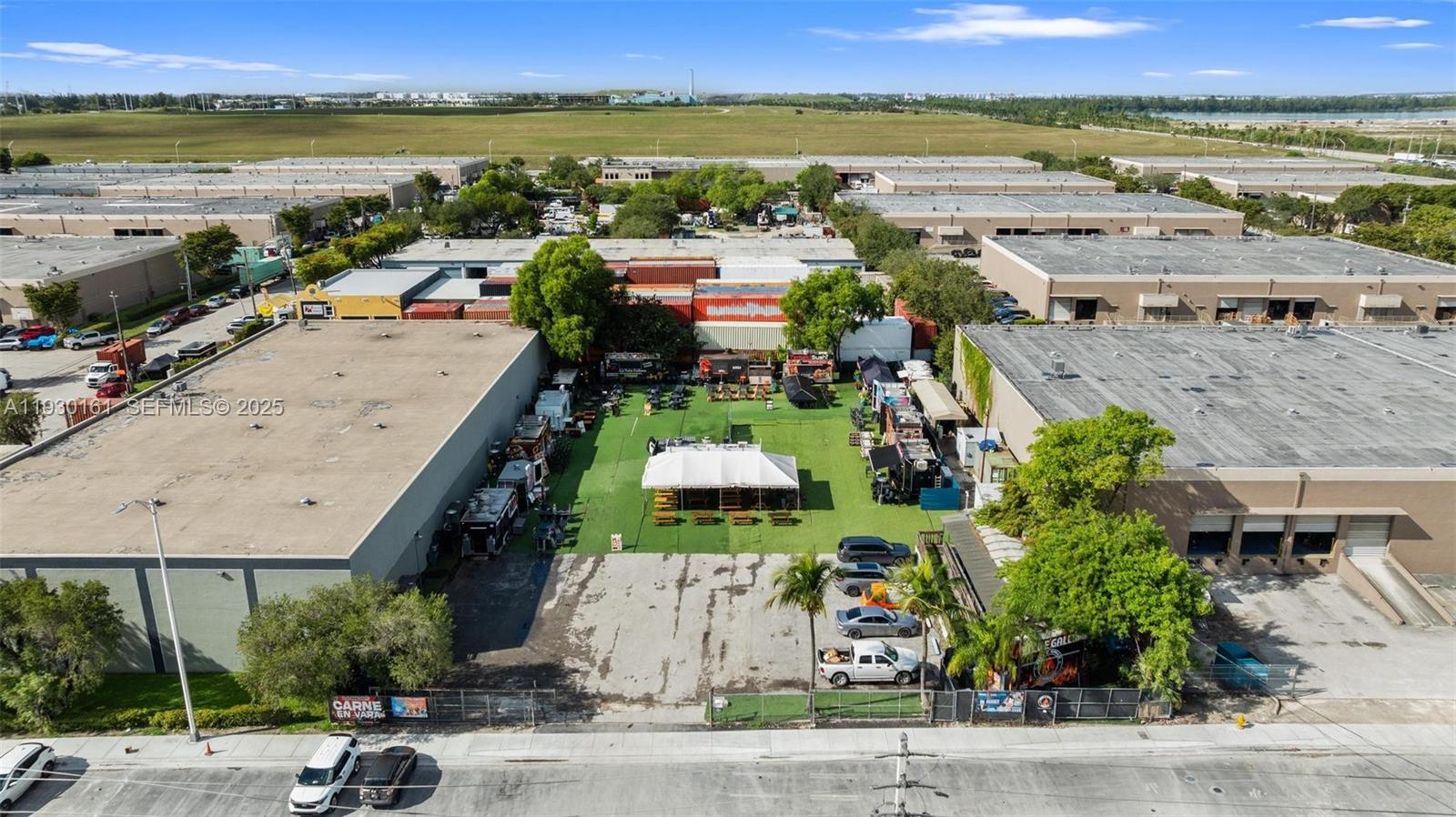 An aerial view shows an outdoor food truck park with a central tent and seating — 7070 NW 84th Ave, Medley FL 33166, MEDLEY, FL