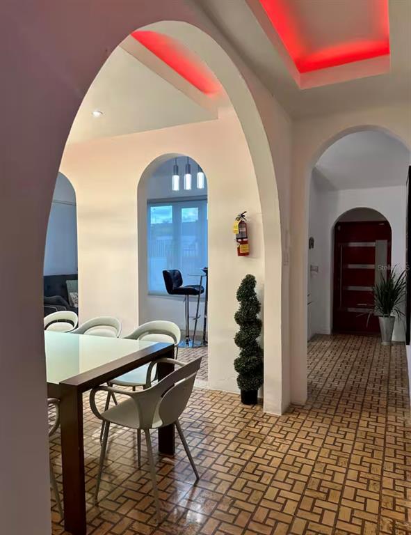 A dining area with arched entryways, tile flooring, and a red-lit recessed ceiling — 13 CALLE VILLA INTERNACIONAL 2, SAN JUAN, PR