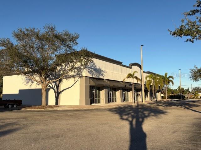 A single-story commercial building with a large parking lot and several palm trees — 10169 TAMIAMI TRAIL UNIT 2125, PUNTA GORDA, FL