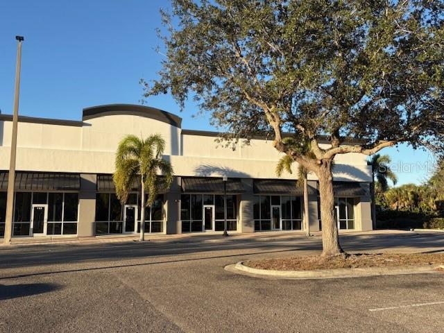 A single-story commercial building with a parking lot and a large tree in front — 10169 TAMIAMI TRAIL UNIT 2125, PUNTA GORDA, FL