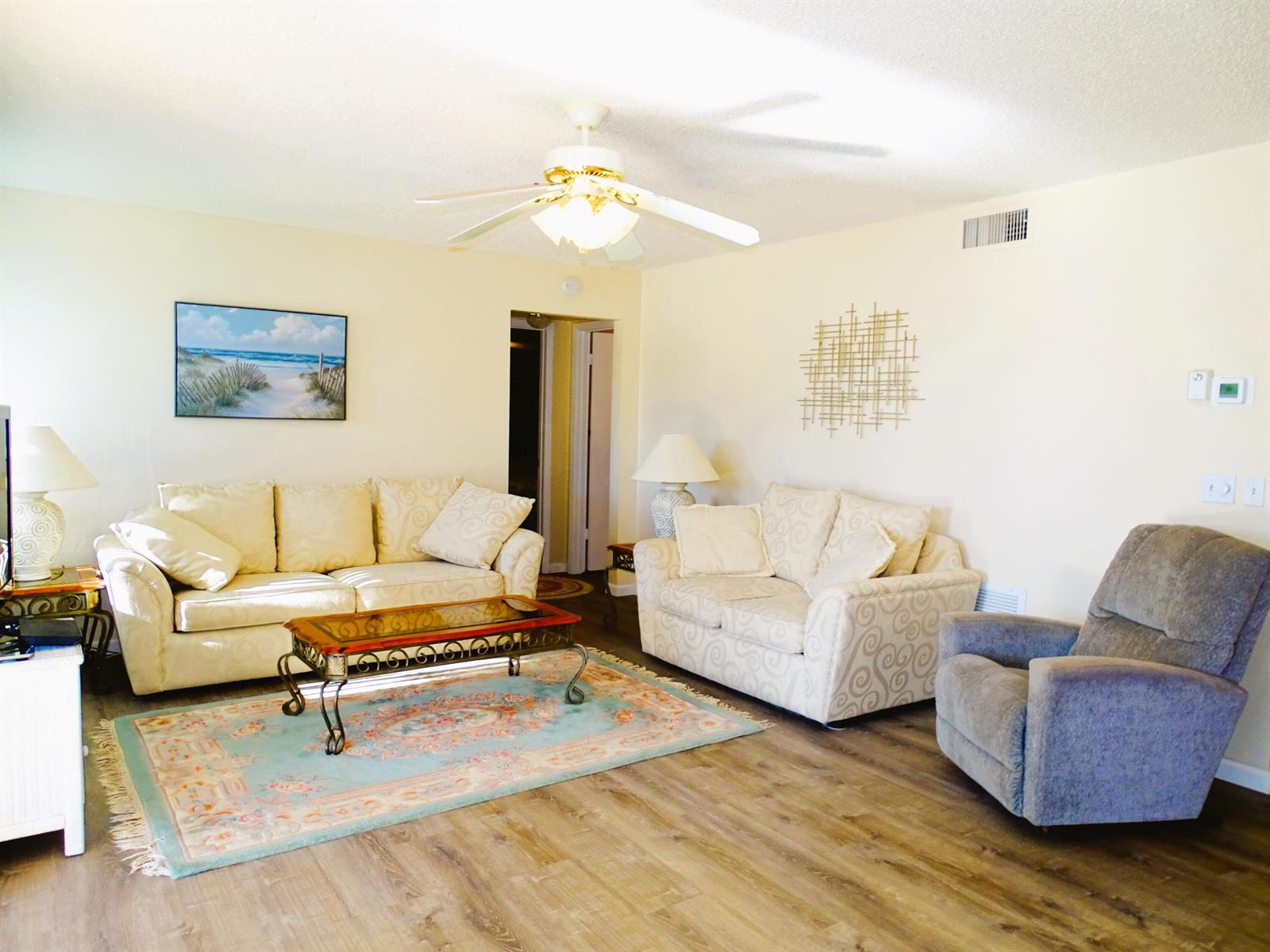 A living room features two beige sofas, a grey recliner, and a patterned area rug — 409 Pine Glen Lane # 2, FL 33463, FL