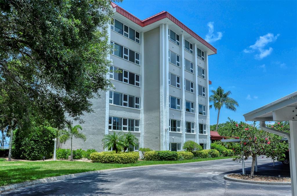 A multi-story apartment building with a light-colored facade and a red roof — 1100 IMPERIAL DRIVE UNIT 108, SARASOTA, FL