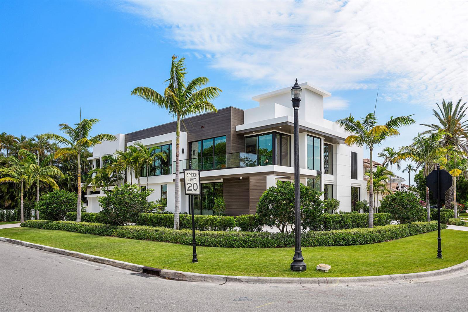 A modern two-story house with wood-paneled accents and large windows sits on a landscaped corner lot — 303 S Maya Palm Drive, Boca Raton FL 33432, BOCA RATON, FL