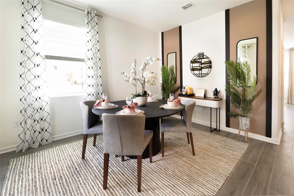 A dining room features a round black table, gray chairs, and decorative wall panels — 6056 PEACEFUL PARK WAY, CLERMONT, FL