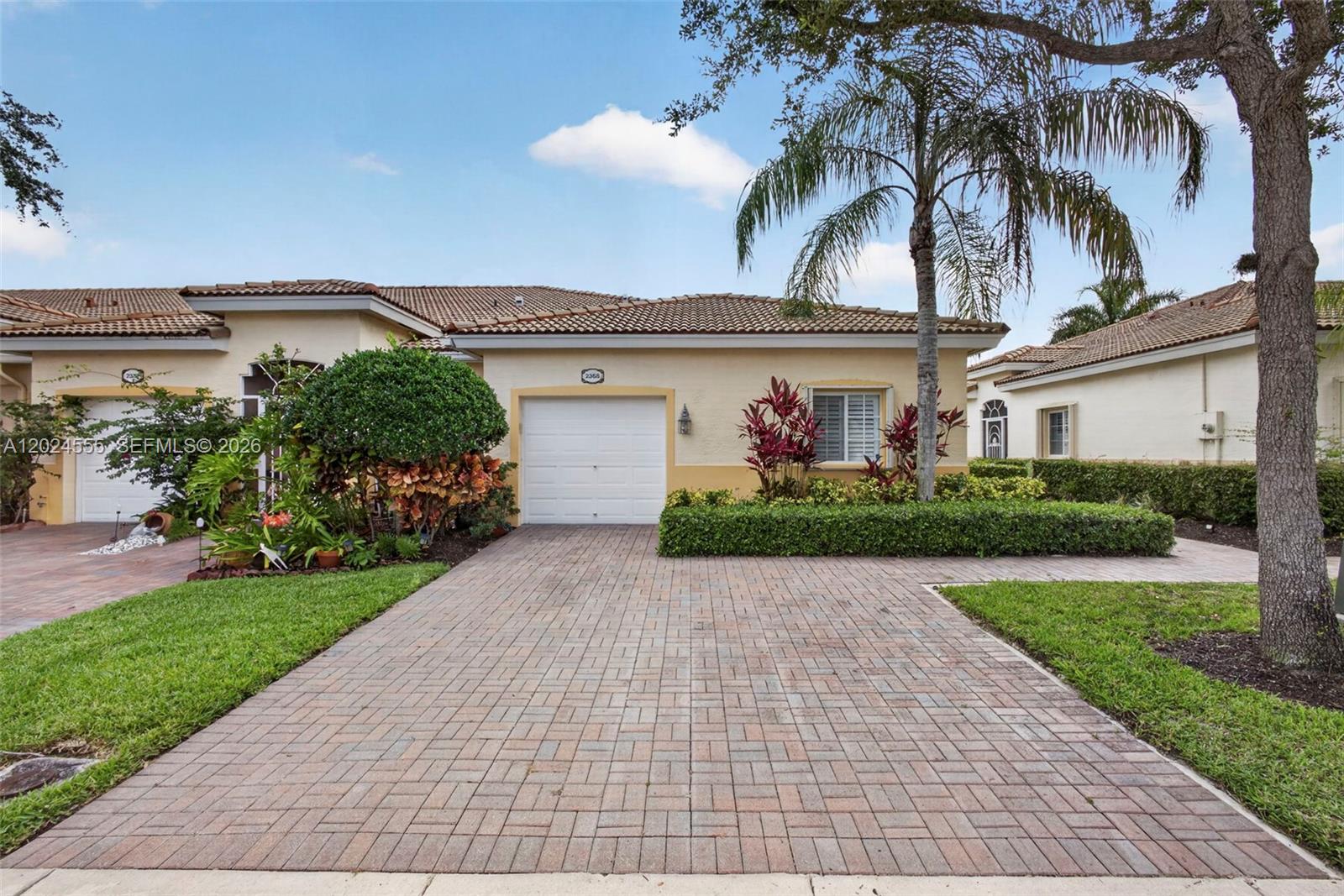 A single-story house with a paved driveway, a white garage door, and a palm tree — 2368 Windjammer Way, West Palm Beach FL 33411, WEST PALM BEACH, FL