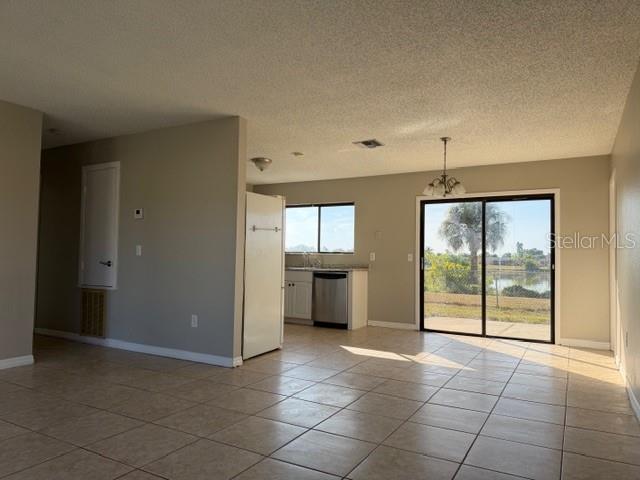 A tiled living area opens to a kitchen with white appliances and a sliding glass door — 5081 ADMINISTRATION STREET, PORT CHARLOTTE, FL