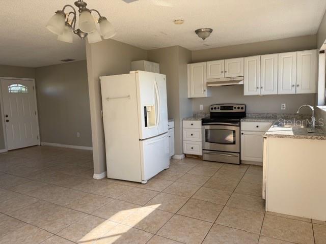 A kitchen with white cabinets, stainless steel appliances, and tile flooring — 5081 ADMINISTRATION STREET, PORT CHARLOTTE, FL