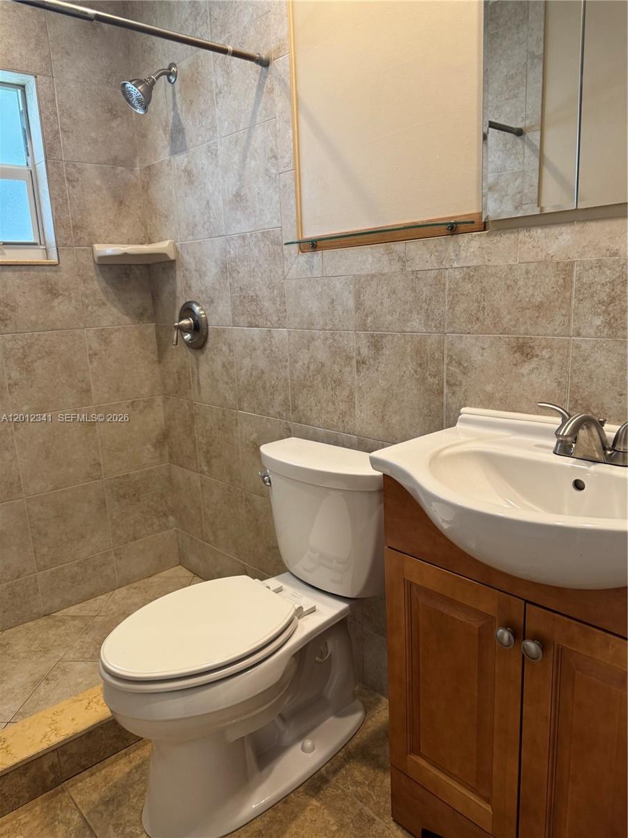 A room with tile floors, a ceiling fan, and built-in wooden shelving units — 1010 NW 72nd Ter # 0, Margate FL 33063, MARGATE, FL