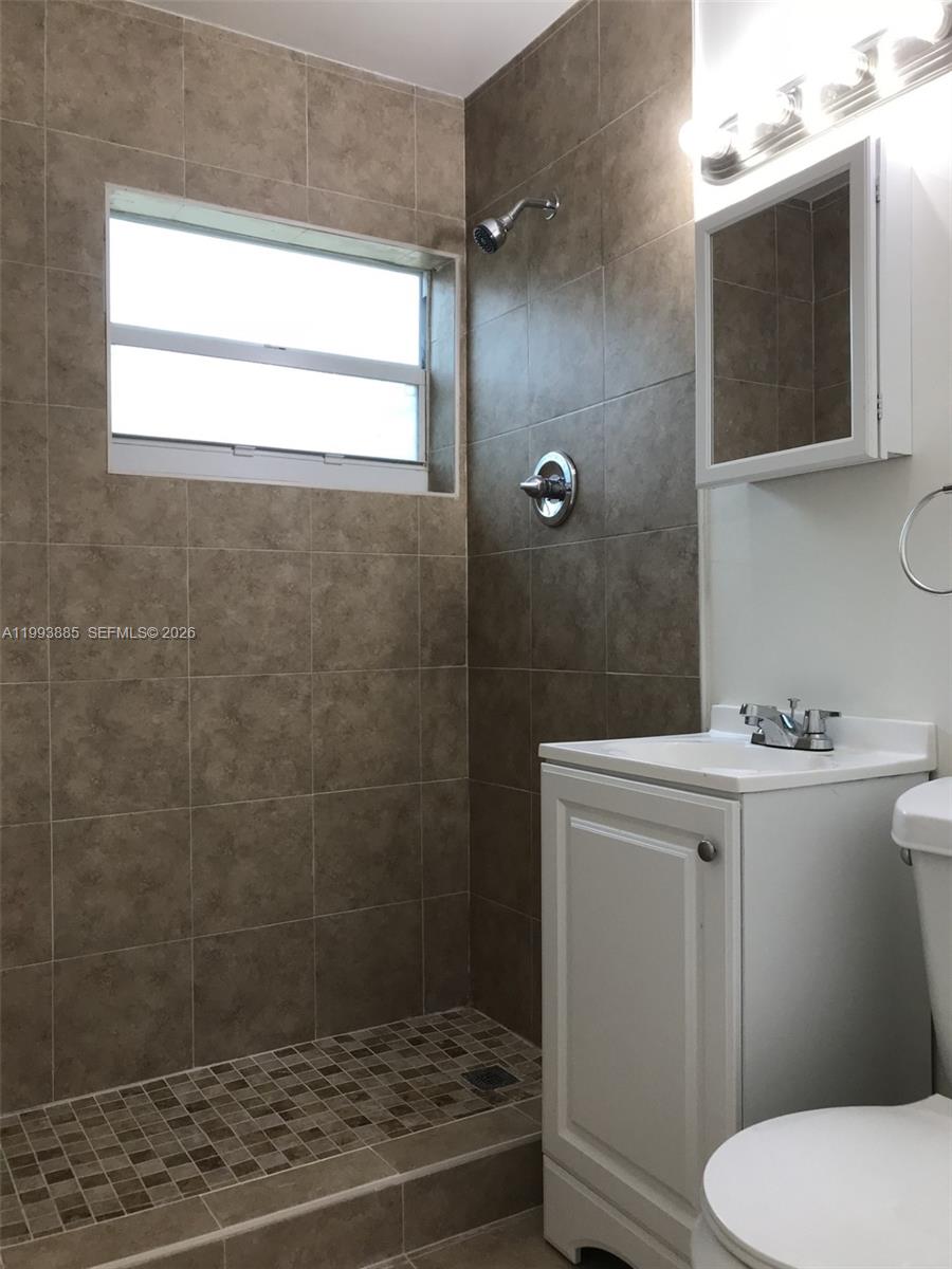 A bathroom features a tiled walk-in shower, a white vanity, and a medicine cabinet — 2362 NW 34th St # 2, Miami FL 33142, MIAMI, FL