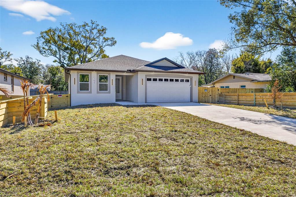 A single-story house with a white exterior, a two-car garage, and a concrete driveway — 284 ROOSEVELT AVENUE, MASARYKTOWN, FL