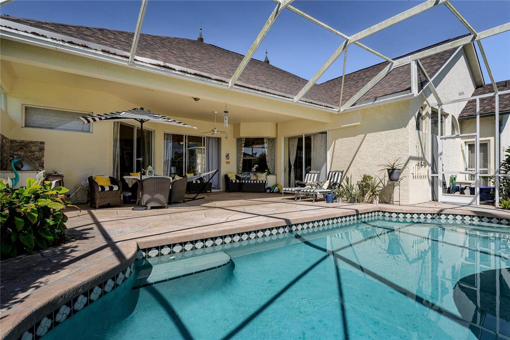 A screened-in patio features a swimming pool, outdoor seating, and sliding glass doors — 3720 59TH AVENUE CIRCLE E, ELLENTON, FL