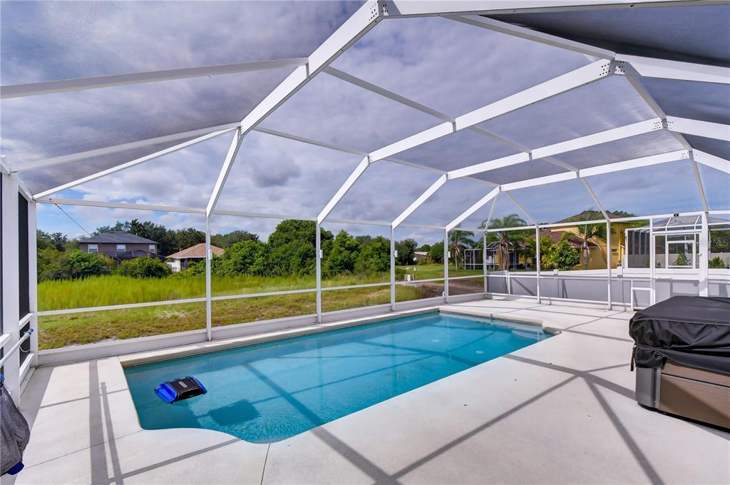 A screened-in swimming pool and patio area with a view of neighboring houses and trees — 11117 RODEO LANE, RIVERVIEW, FL