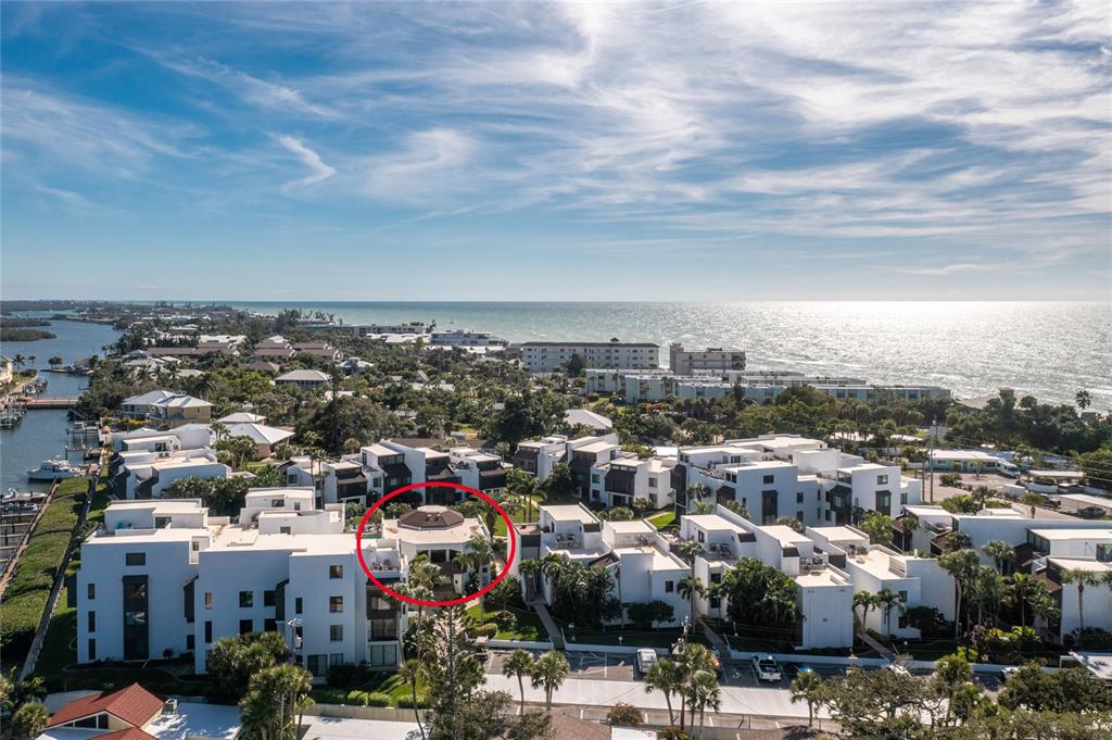 An aerial view shows a white multi-story residential complex with a red-circled rooftop structure — 2955 N BEACH ROAD UNIT E122, ENGLEWOOD, FL