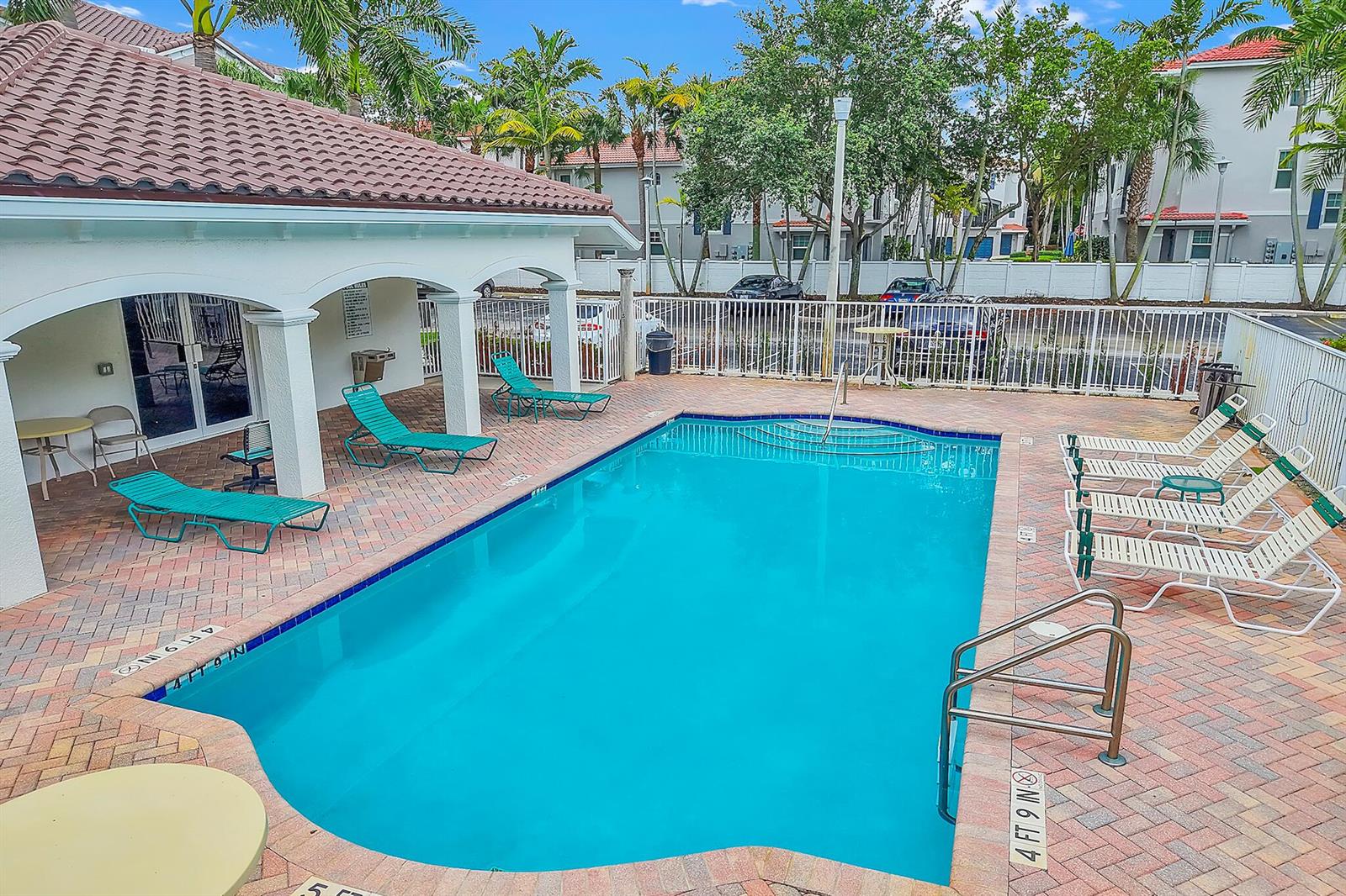 An outdoor swimming pool with lounge chairs on a brick patio next to a building — 528 Bayfront Drive, Boynton Beach FL 33435, BOYNTON BEACH, FL