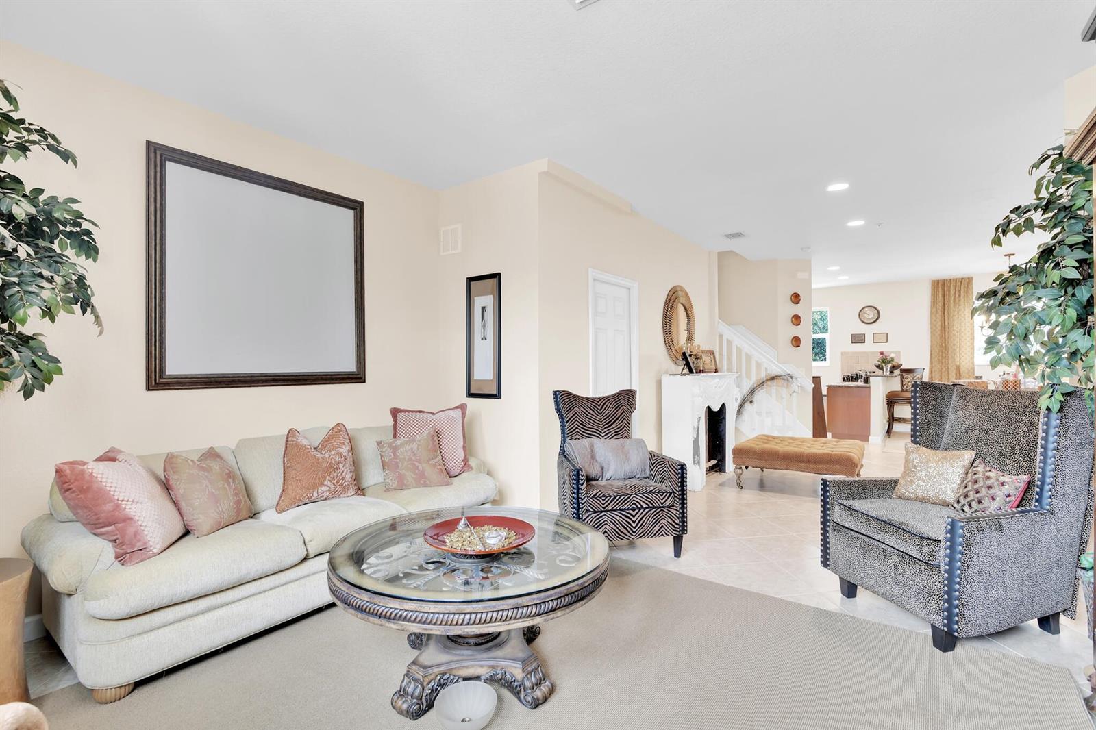 A living room features a beige sofa, two patterned armchairs, and a round glass coffee table — 528 Bayfront Drive, Boynton Beach FL 33435, BOYNTON BEACH, FL