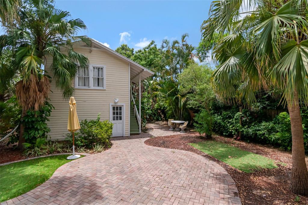 A living room features a white brick fireplace, hardwood floors, and a green sectional sofa — 126 8TH AVENUE NE, ST PETERSBURG, FL