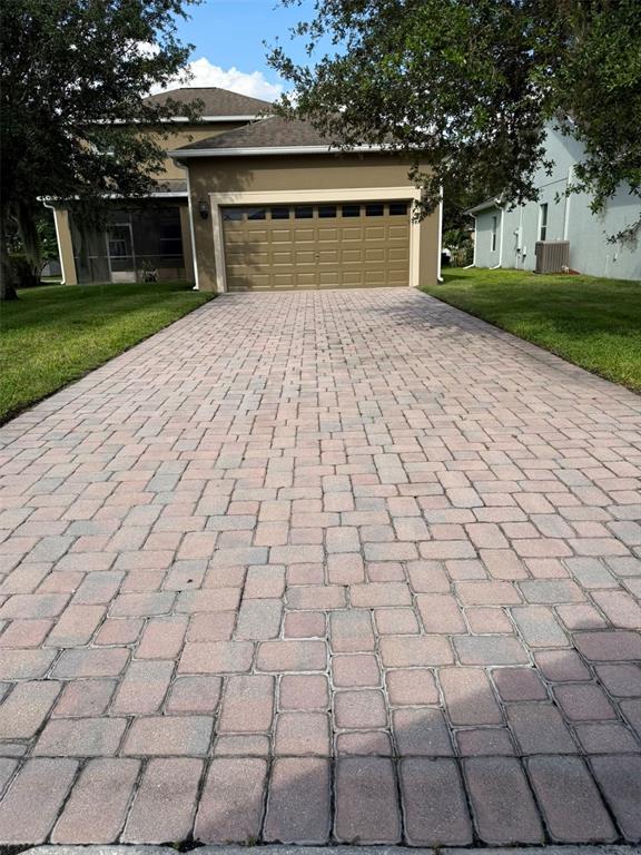 A paved driveway leads to the two-car garage of a two-story suburban home — 6206 POINT HANCOCK DRIVE, WINTER GARDEN, FL