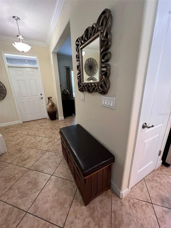 An entryway features a dark wooden storage bench, an ornate mirror, and tiled flooring — 6206 POINT HANCOCK DRIVE, WINTER GARDEN, FL