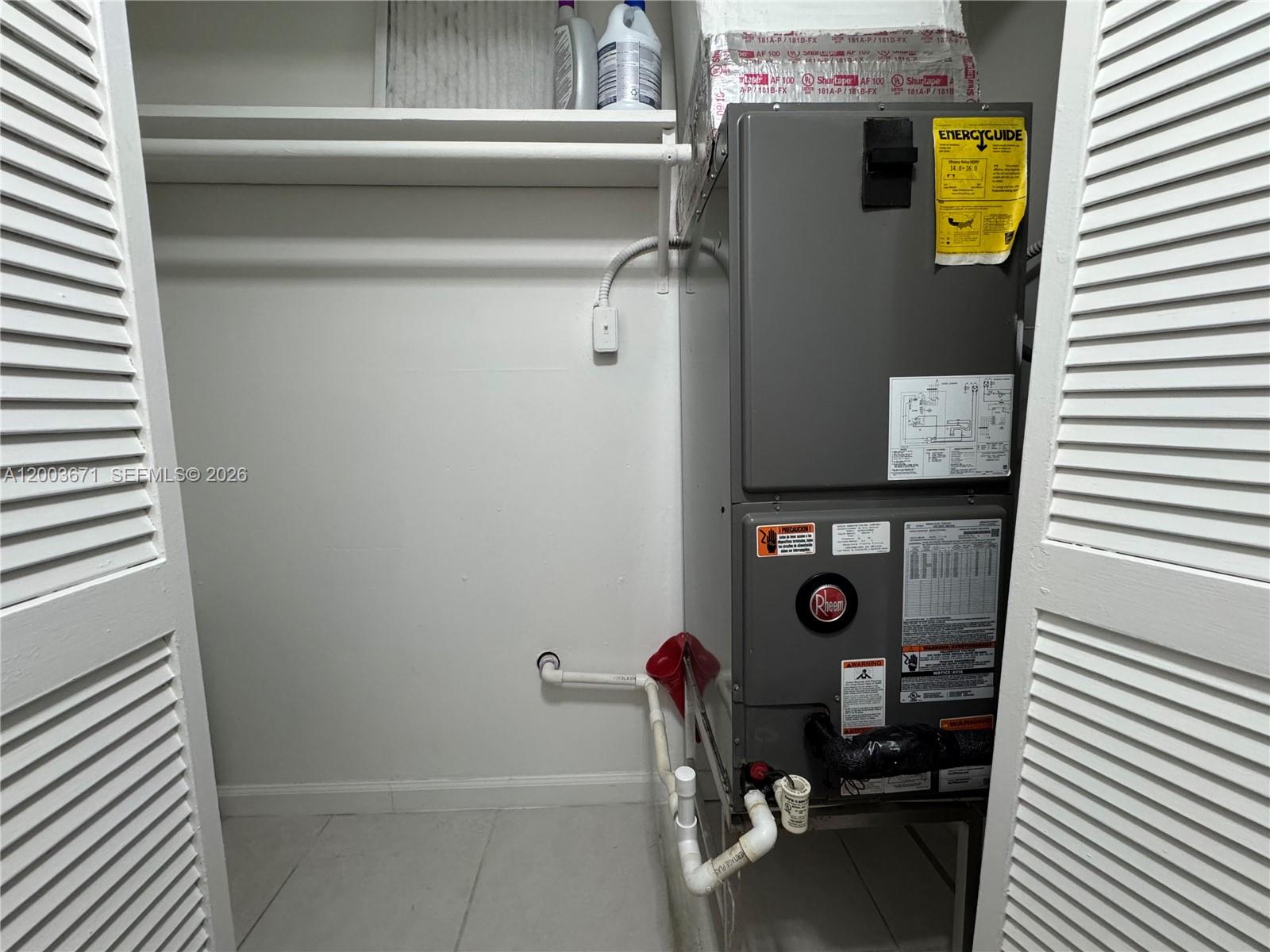 A closet contains a Rheem HVAC unit with exposed plumbing and a white shelf above — 2020 NE 135th St # 810, North Miami FL 33181, NORTH MIAMI, FL