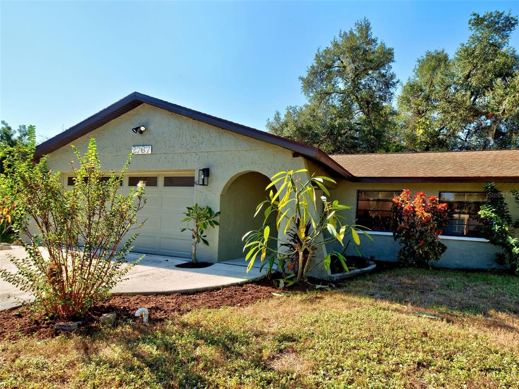 A single-story house with a light-colored stucco exterior, a garage, and a covered entryway — 2767 SALLY LANE, NORTH PORT, FL