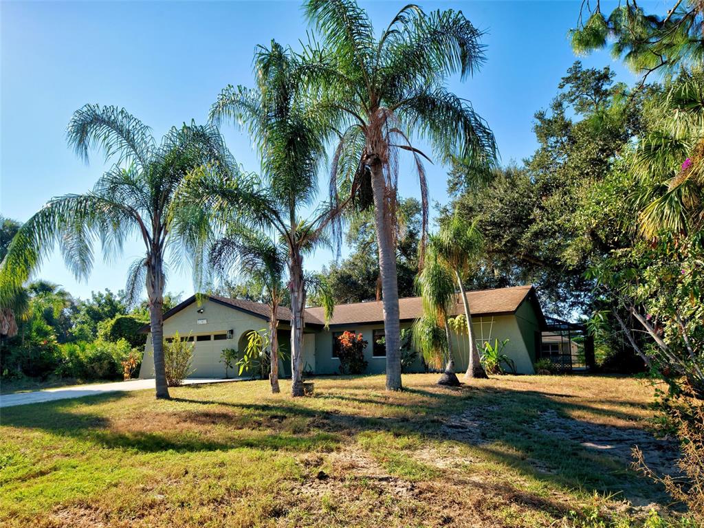 A single-story house with a tan exterior and palm trees in the front yard — 2767 SALLY LANE, NORTH PORT, FL