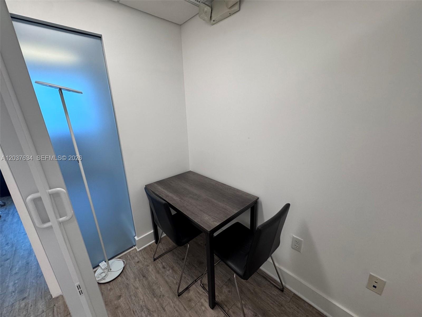 A small room features a dark wood table, two black chairs, and a floor lamp — 40 SW 13th St # 402, Miami FL 33130, MIAMI, FL