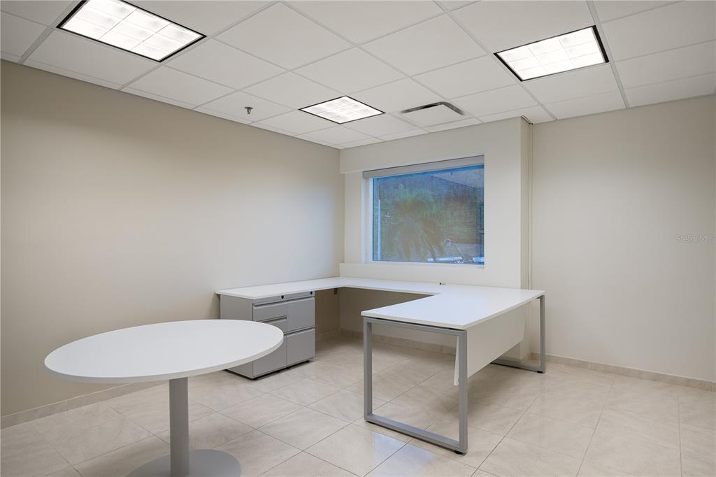 An office with a white U-shaped desk, a round table, and tile flooring — 90 CARR 165 SUITE 309 CENTRO INTERNACIONAL DE MERCADEO, GUAYNABO, PR