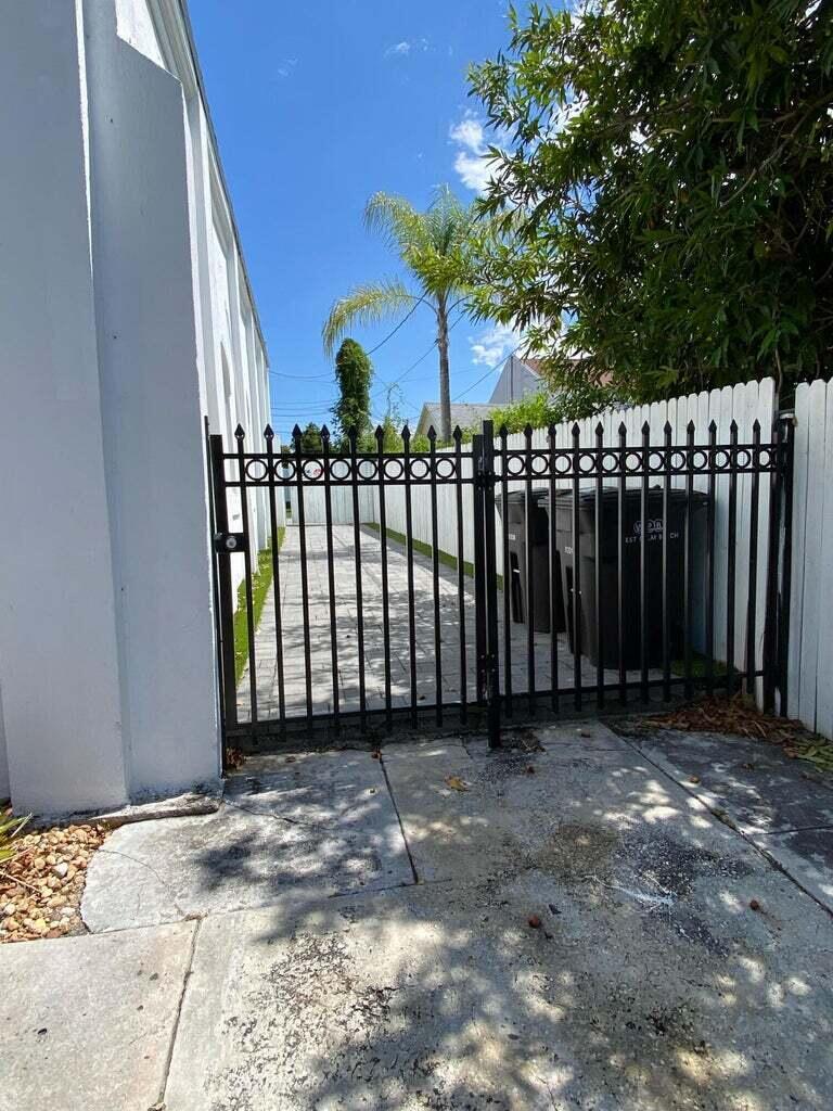 A light blue two-story building features an exterior staircase leading to an upper-level blue door — 816 9th Street, West Palm Beach FL 33401, WEST PALM BEACH, FL