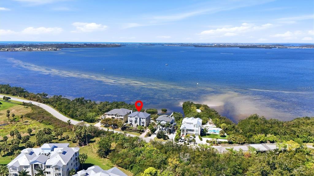 An aerial view shows waterfront houses along a road with a red location marker — 3308 PALMA SOLA BOULEVARD, BRADENTON, FL