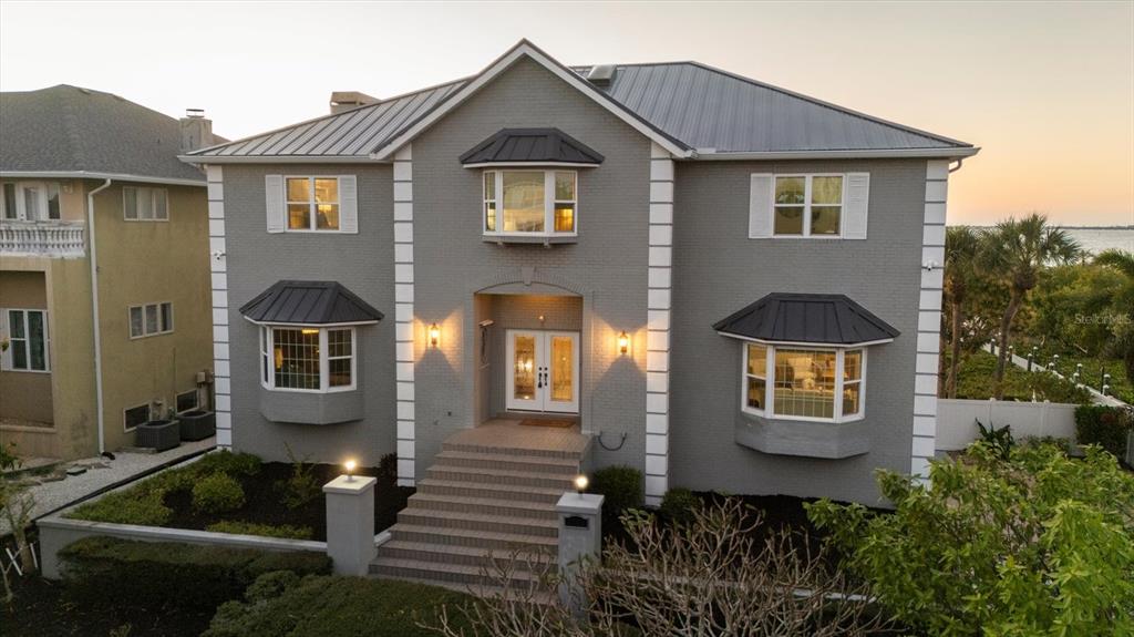 A two-story gray brick house with a metal roof and a front staircase — 3308 PALMA SOLA BOULEVARD, BRADENTON, FL