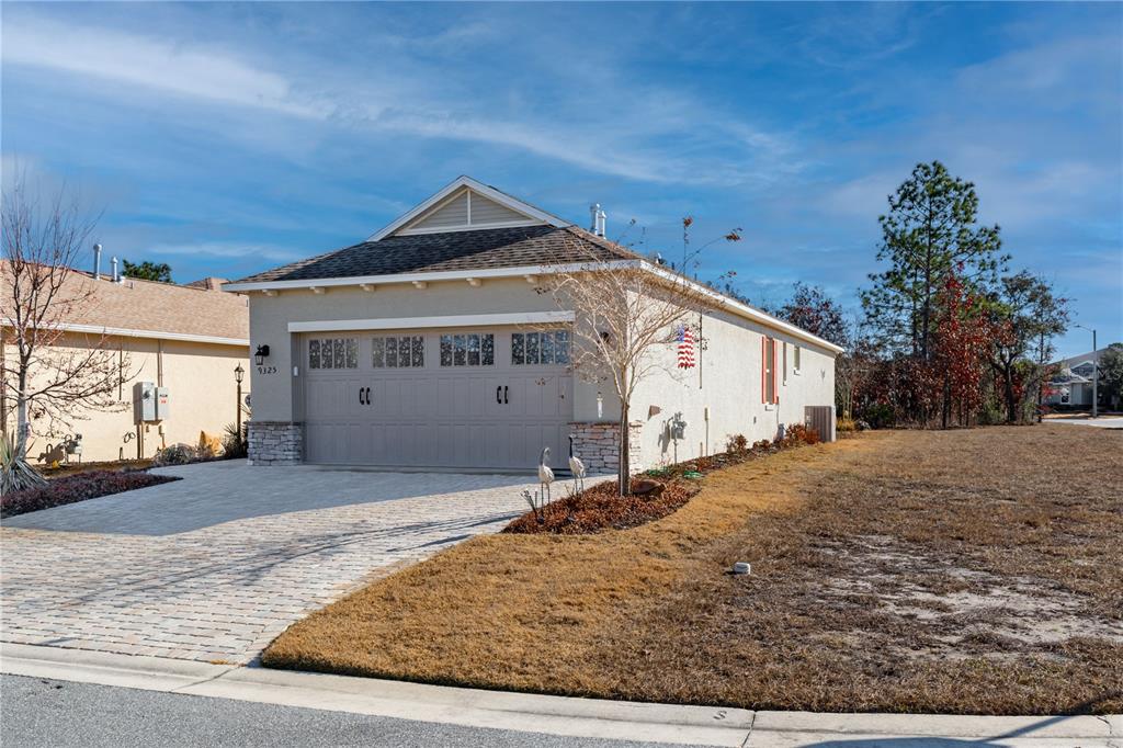 A single-story house with a beige stucco exterior, a two-car garage, and a paved driveway — 9325 SW 106TH AVENUE, OCALA, FL
