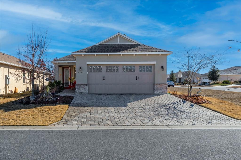 A single-story house with a beige stucco exterior, a two-car garage, and a paved driveway — 9325 SW 106TH AVENUE, OCALA, FL