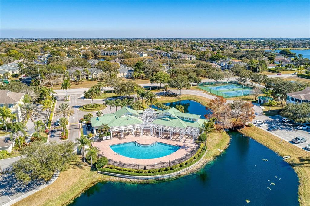 An aerial view shows a community clubhouse with a pool, tennis courts, and a lake — 4802 51ST STREET W UNIT 1311, BRADENTON, FL