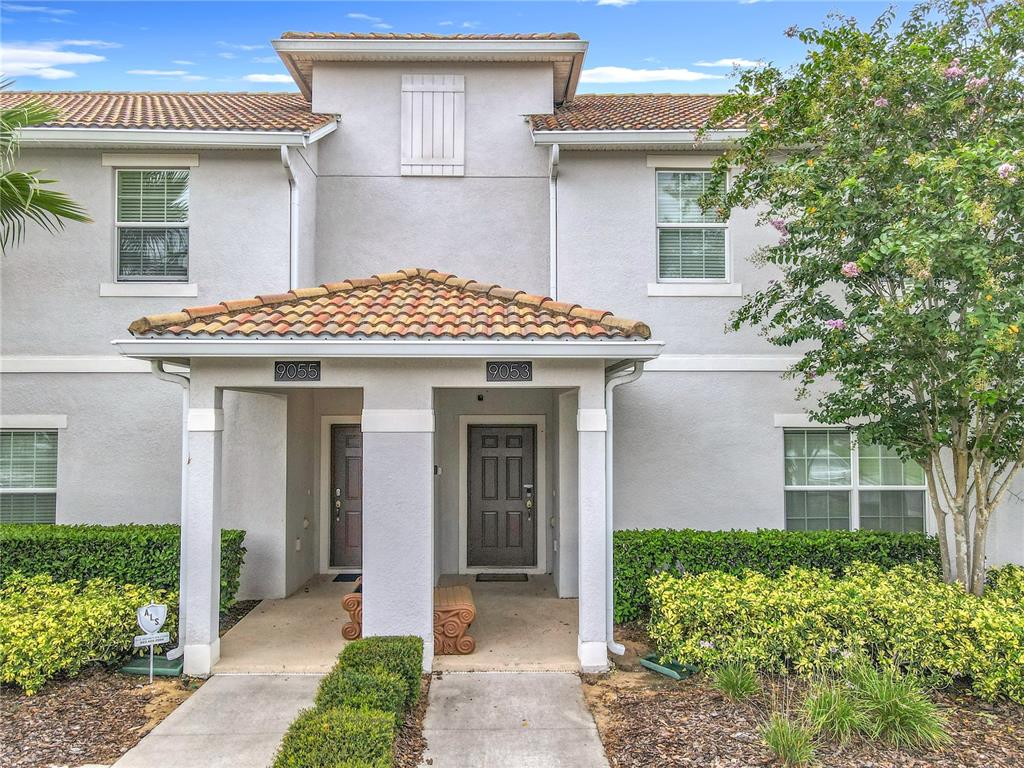 A living room features gray tile floors, a tufted sectional sofa, and sliding glass doors — 9053 DOGLEG DRIVE, DAVENPORT, FL
