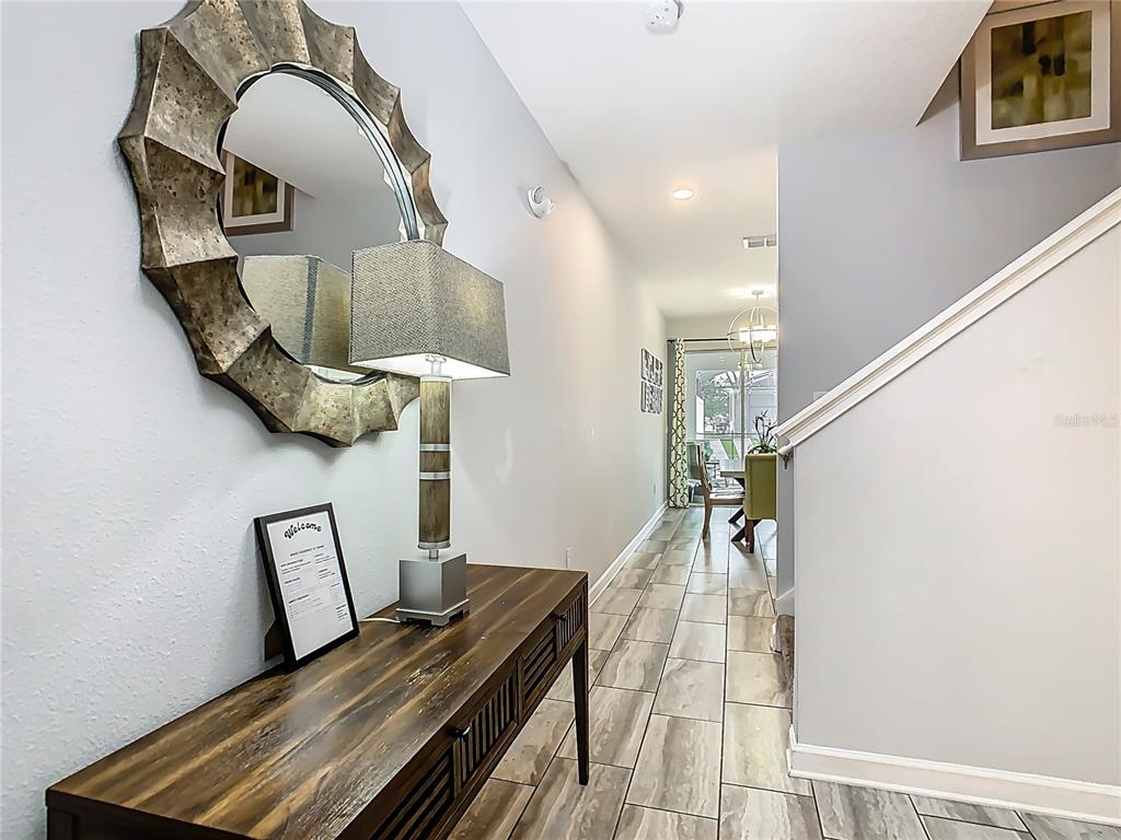 An open-concept kitchen and dining area features white cabinetry, a breakfast bar, and tile flooring — 9053 DOGLEG DRIVE, DAVENPORT, FL