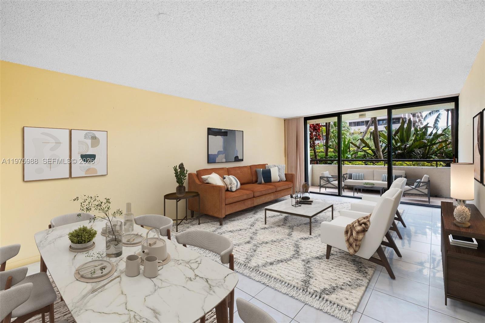 A living and dining room with a marble table, brown sofa, and a balcony view — 170 Ocean Lane Dr # 310, Key Biscayne FL 33149, KEY BISCAYNE, FL
