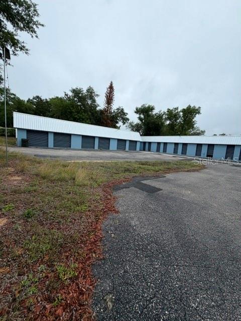 A long, single-story blue storage facility building with a white metal roof — 651 W DESOTO STREET, CLERMONT, FL