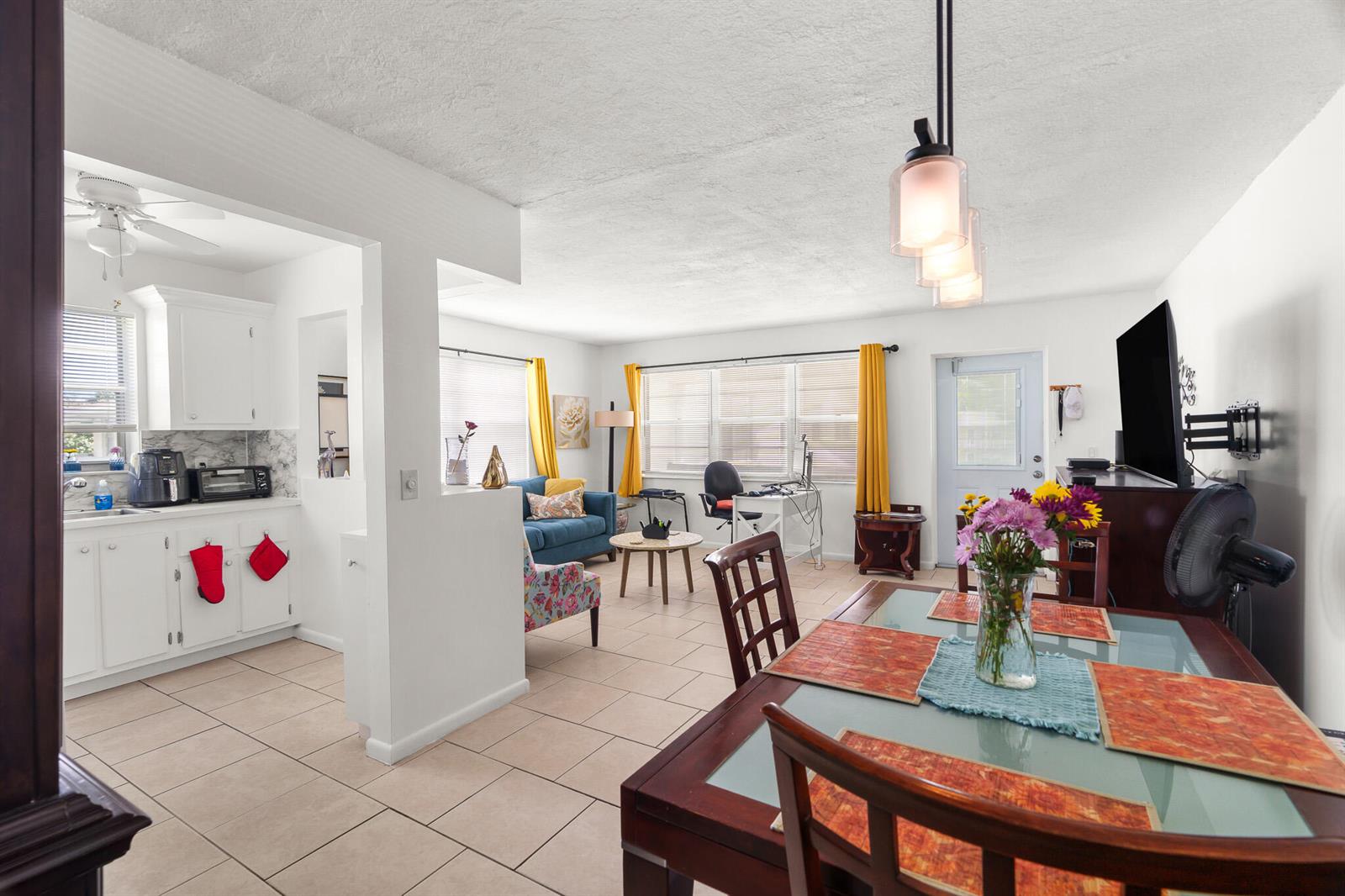 An open-concept living area features a kitchen, dining space, and lounge with tile flooring — 347 Windsor O, West Palm Beach FL 33417, WEST PALM BEACH, FL