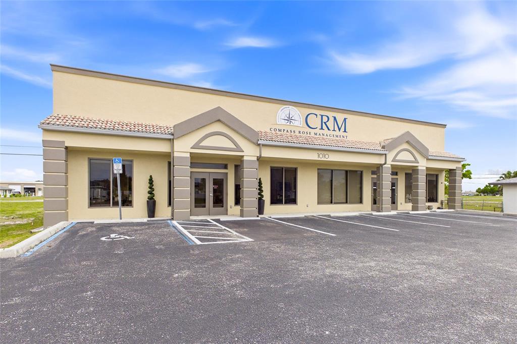 A one-story commercial building with a beige stucco exterior and a parking lot — 1010 NE 9TH STREET UNIT A, CAPE CORAL, FL