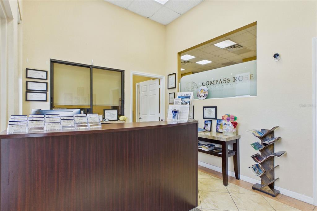 A reception area features a dark wood desk, a glass partition, and a brochure rack — 1010 NE 9TH STREET UNIT A, CAPE CORAL, FL