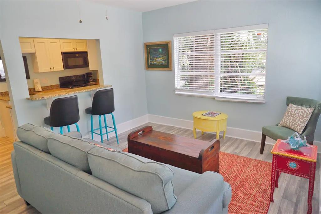 A living room with a sofa, wooden coffee table, and a breakfast bar with stools — 601 N OSCEOLA AVENUE, CLEARWATER, FL