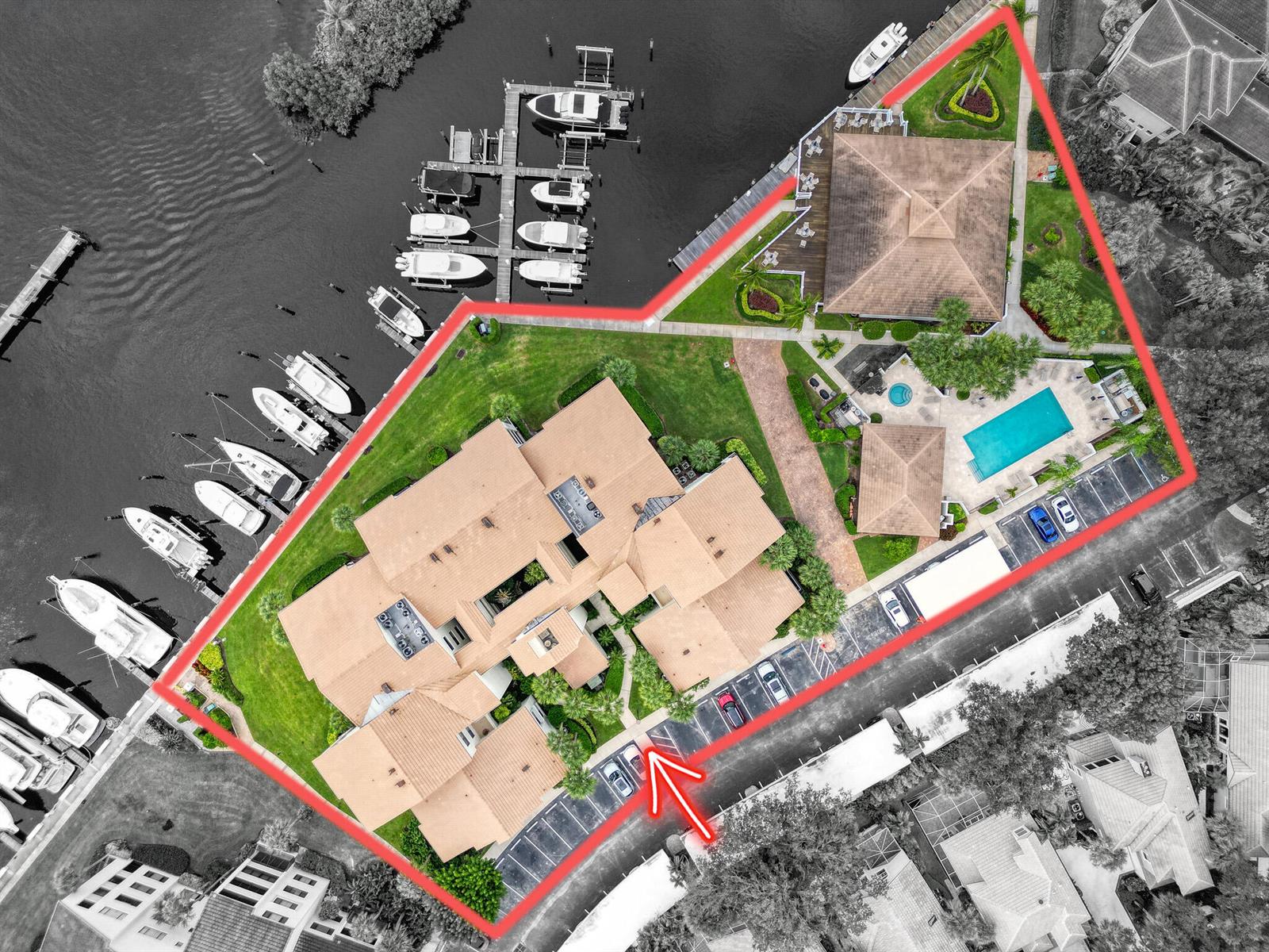 Aerial view of a waterfront residential complex with a pool, boat slips, and parking — 827 Oak Harbour Drive, Juno Beach FL 33408, JUNO BEACH, FL