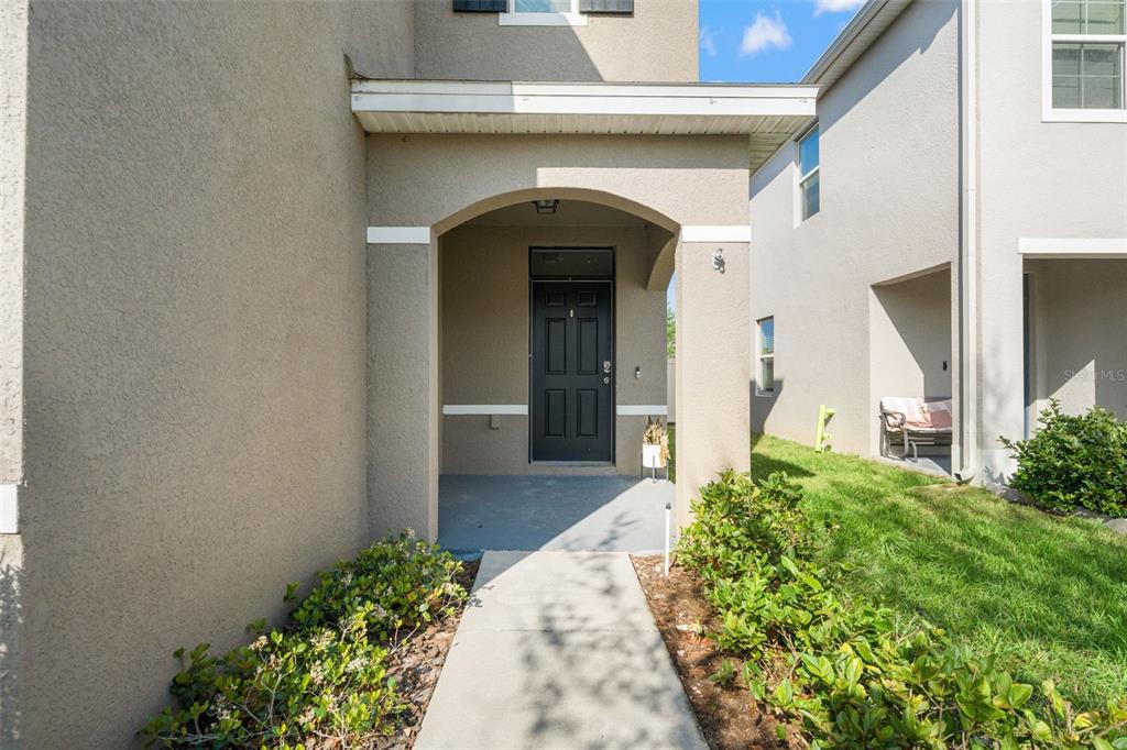The exterior view shows a covered entryway with a dark front door and concrete walkway — 6663 SEAWAY DRIVE, BROOKSVILLE, FL