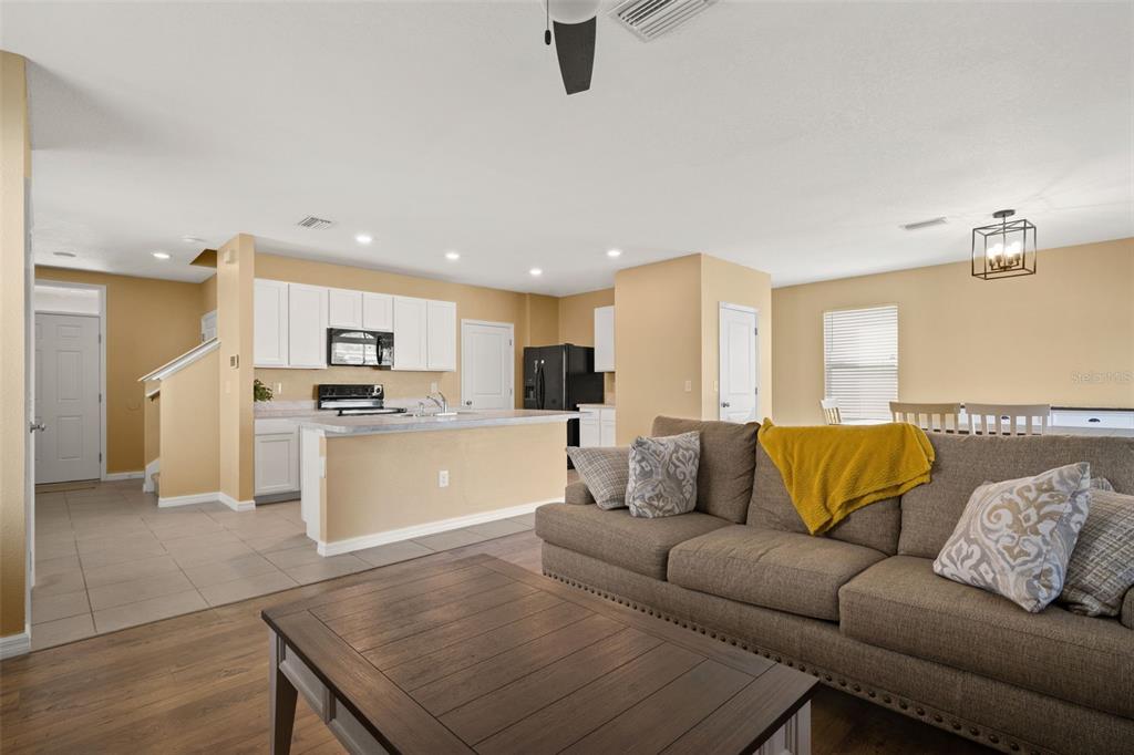 A living room with a brown sofa and coffee table opens to a white kitchen — 6663 SEAWAY DRIVE, BROOKSVILLE, FL