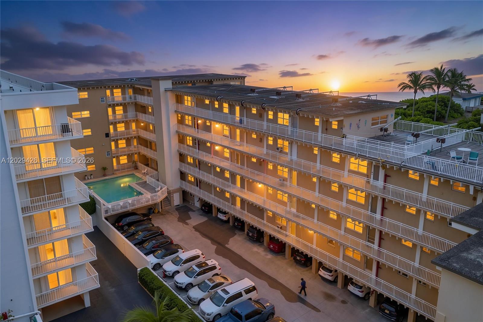 An aerial view shows a multi-story apartment complex with a pool and parking area — 4500 S Ocean Blvd # 405, Lantana FL 33480, LANTANA, FL